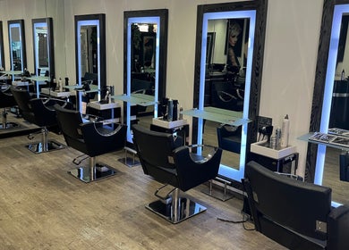 Modern salon interior at Charlotte Miller Hair Design, Marlow, England, GB, showcasing sleek styling stations.