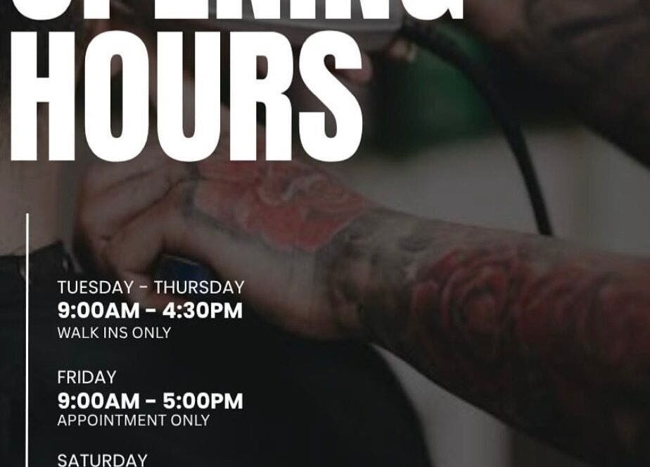 Tattooed barber at Yass_Fadez in Bexley, NSW, showcasing unique opening hours with professional grooming.