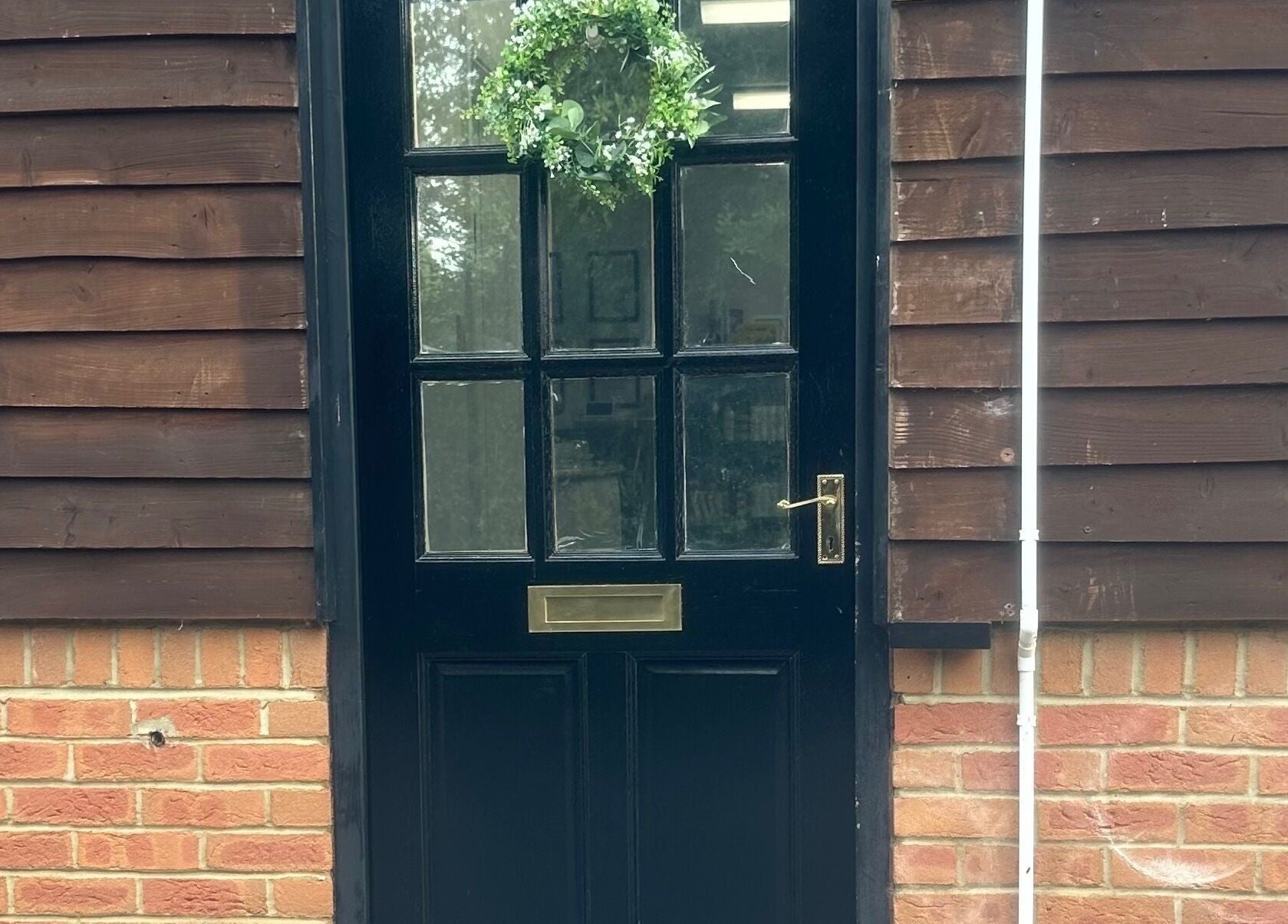 Welcoming black door with greenery at No.4 Aesthetics & Beauty, St Albans, England, GB.