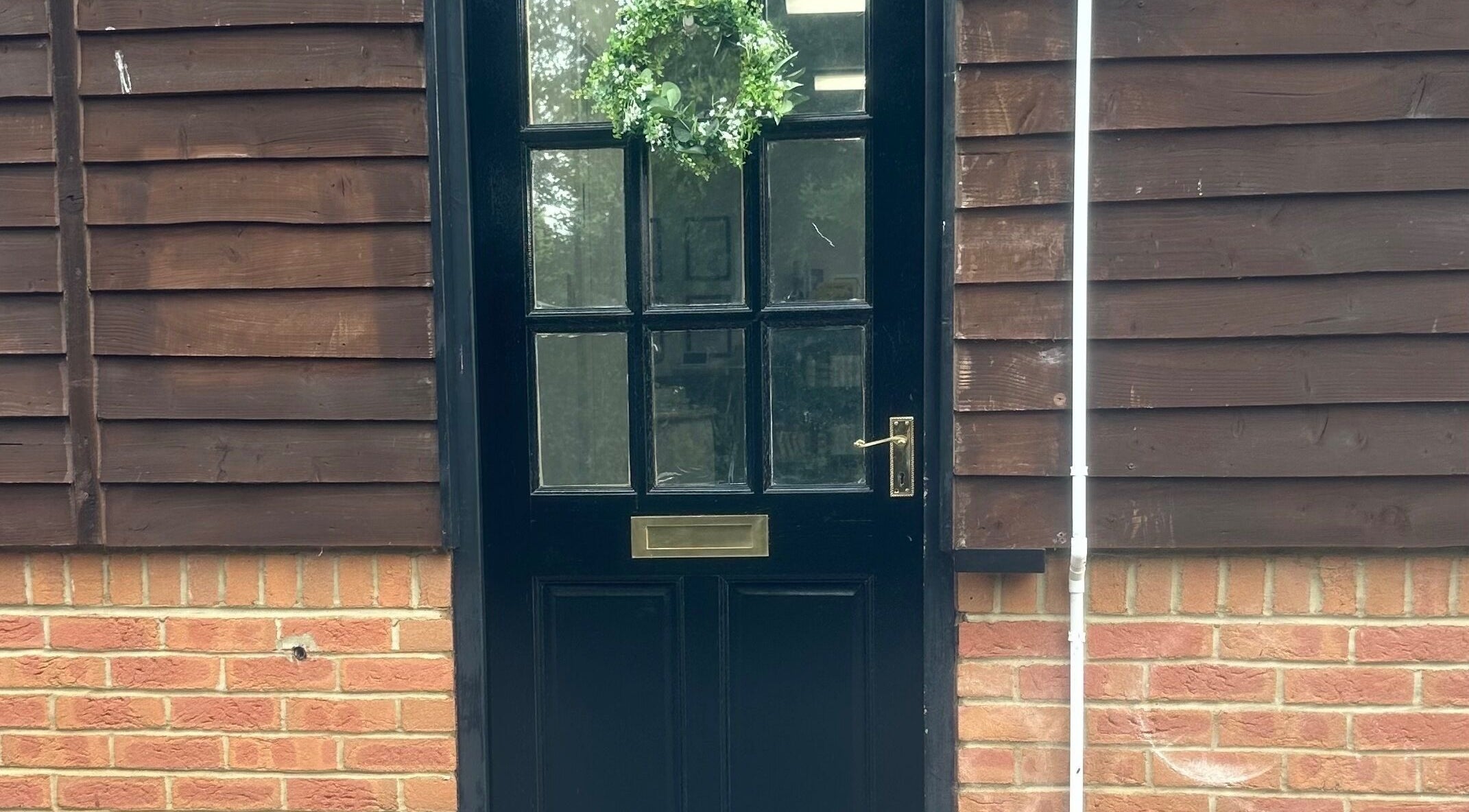 Welcoming black door with greenery at No.4 Aesthetics & Beauty, St Albans, England, GB.