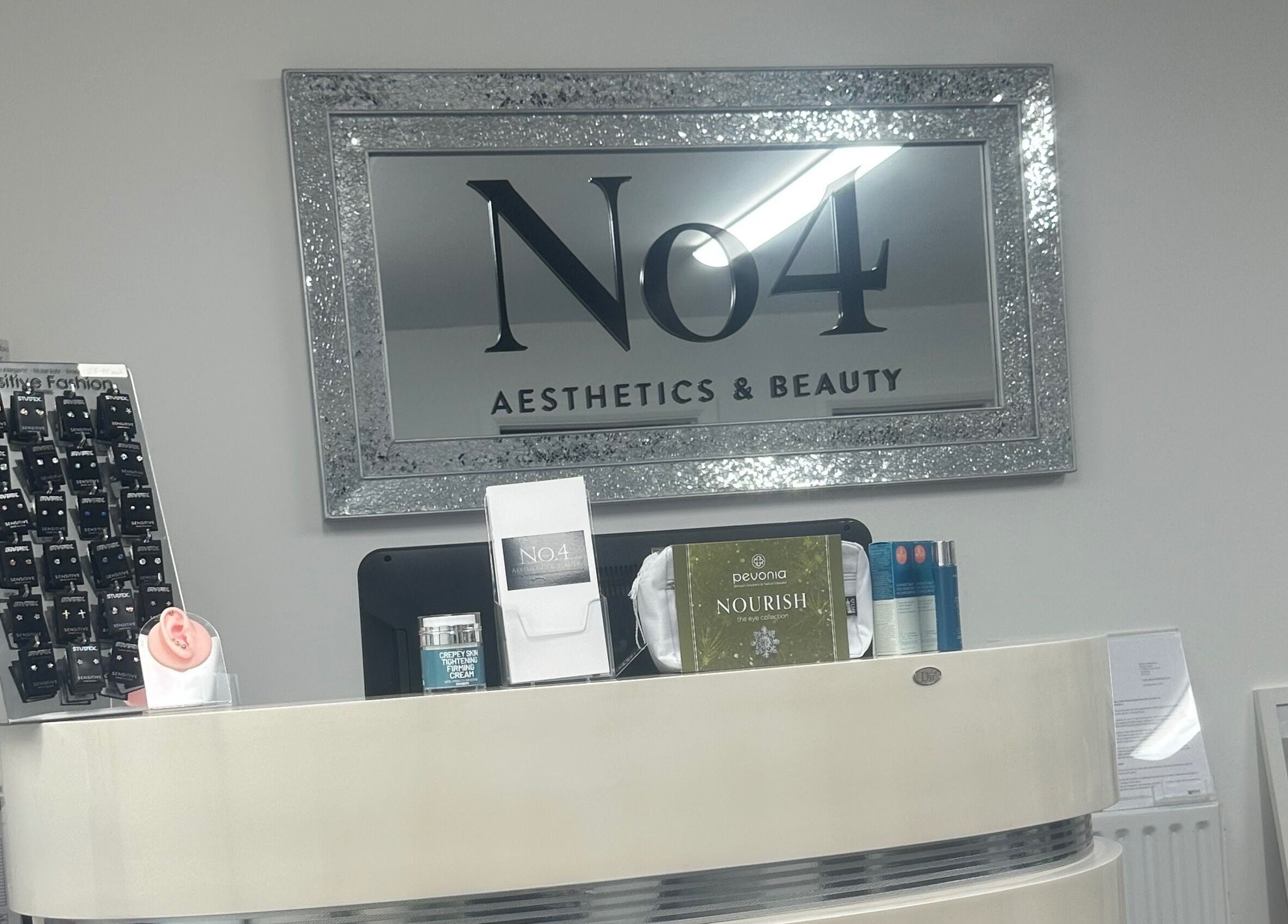 Reception desk at No .4 Aesthetics & Beauty in St Albans, England, GB with elegant decor and beauty products.