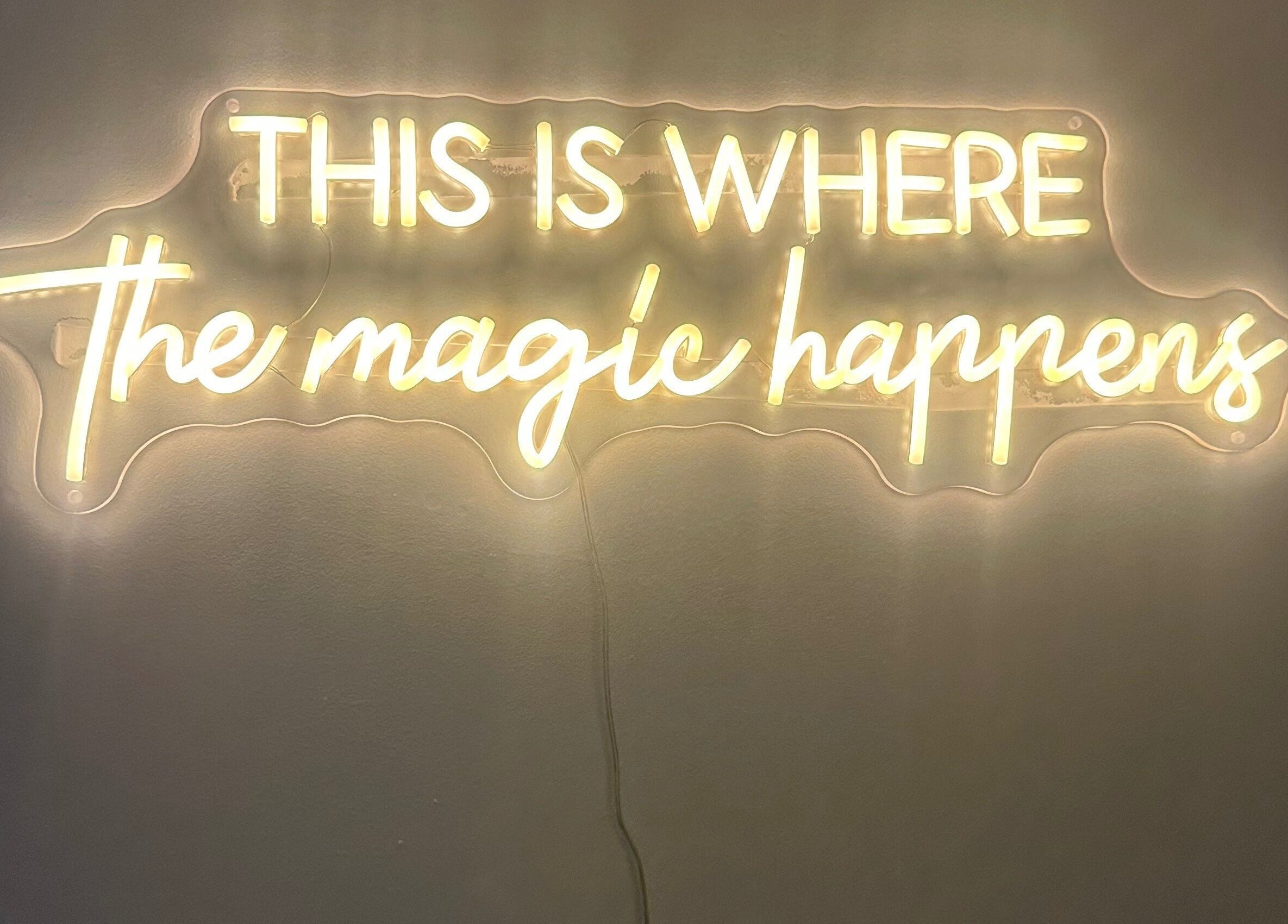Illuminated sign reading 'This is where the magic happens' at No .4 Aesthetics & Beauty, St Albans, England, GB.