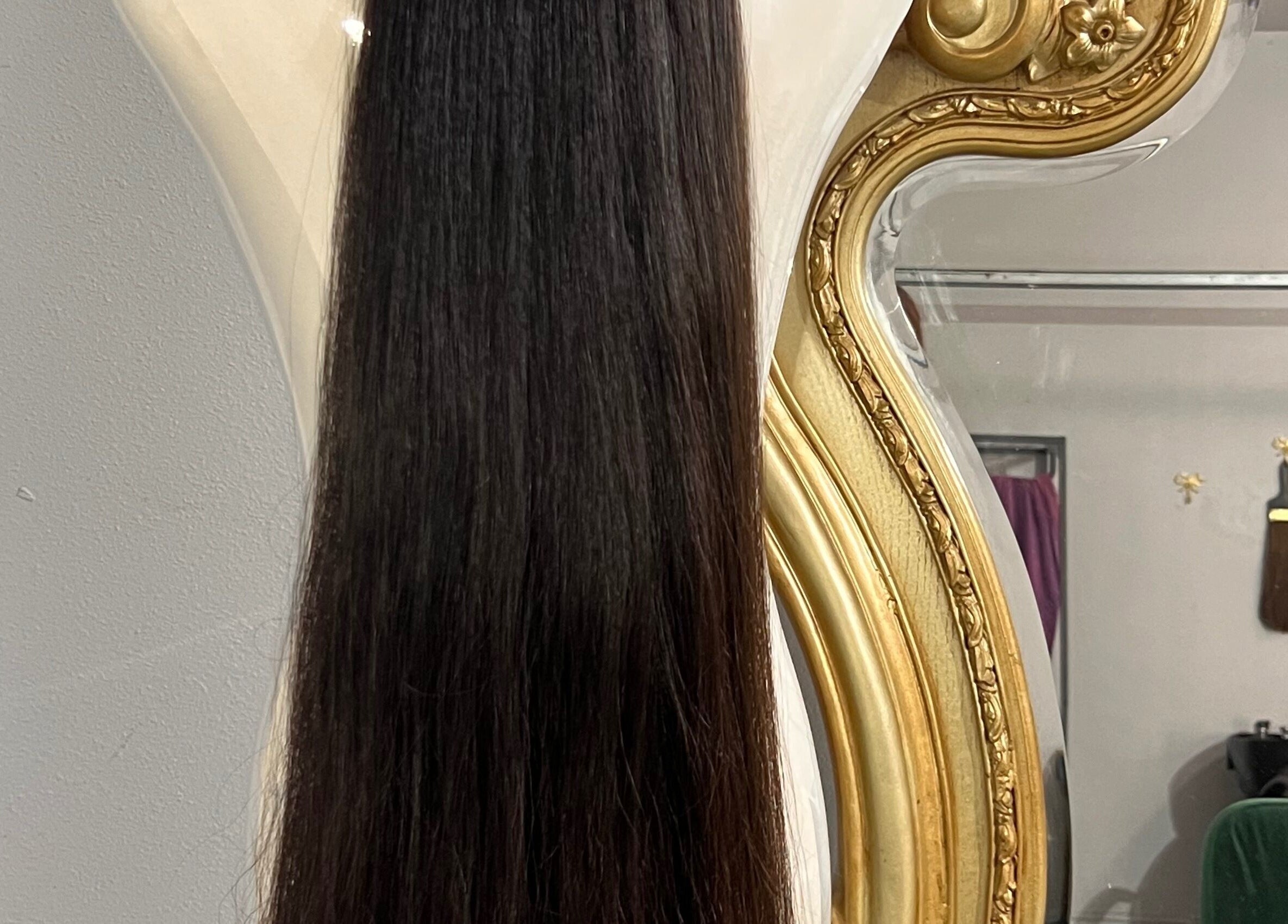 Elegant hair extensions displayed against a luxurious mirror at Hair Extensions by Denise, Mission, Texas, US.