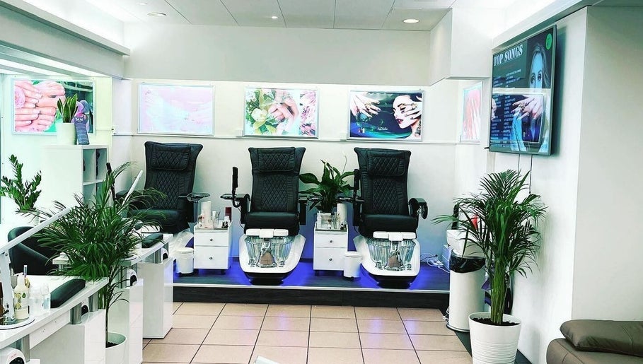 Innenraum von The Garden Nails - Lenzburg, Aargau, CH mit stilvollen Pedikürstühlen und Pflanzen.