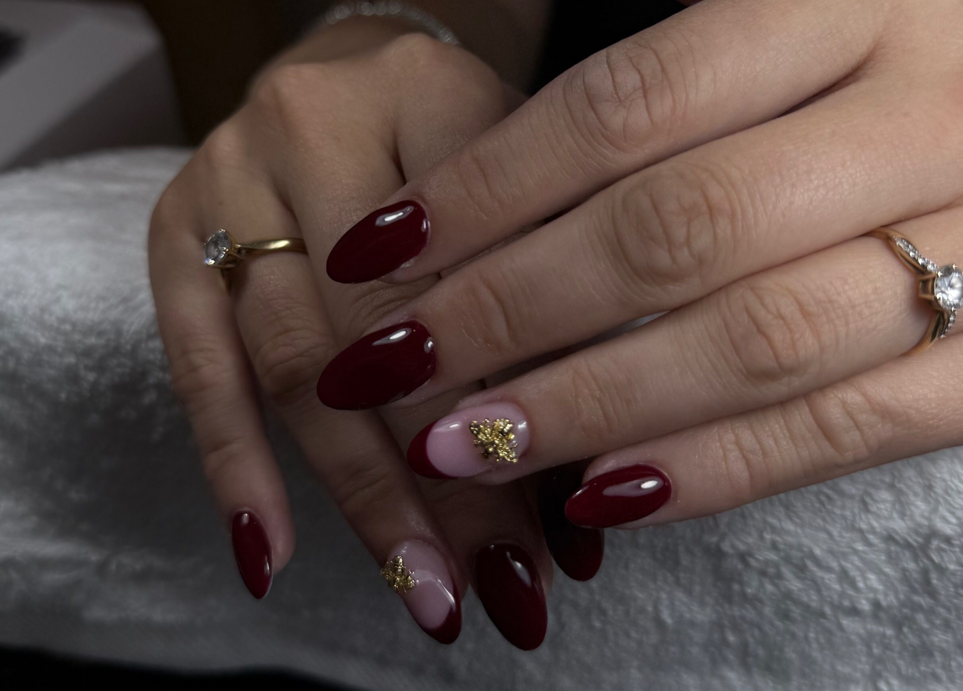 Manucure rouge élégante avec déco dorée chez DJ Nails à Crépy, Hauts-de-France, FR.