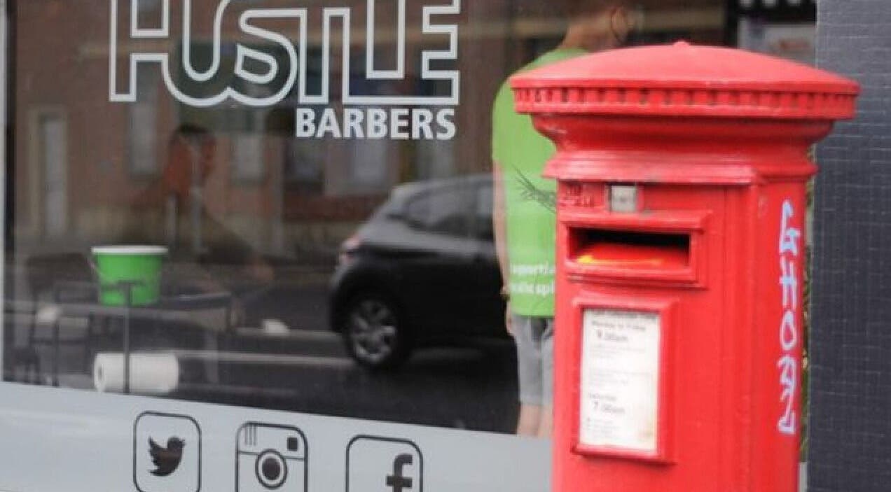 Hustle Barbers storefront with a classic red postbox in Chesterfield, England, GB.