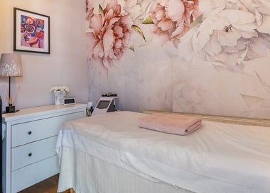 Tranquil treatment room at Studio Figura Ealing, London, England, GB with floral walls and cozy decor.
