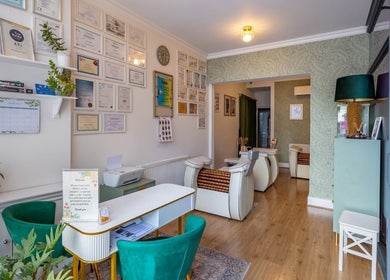 Elegant interior of Studio Figura Ealing in London, England, GB with certificates and cozy seating.