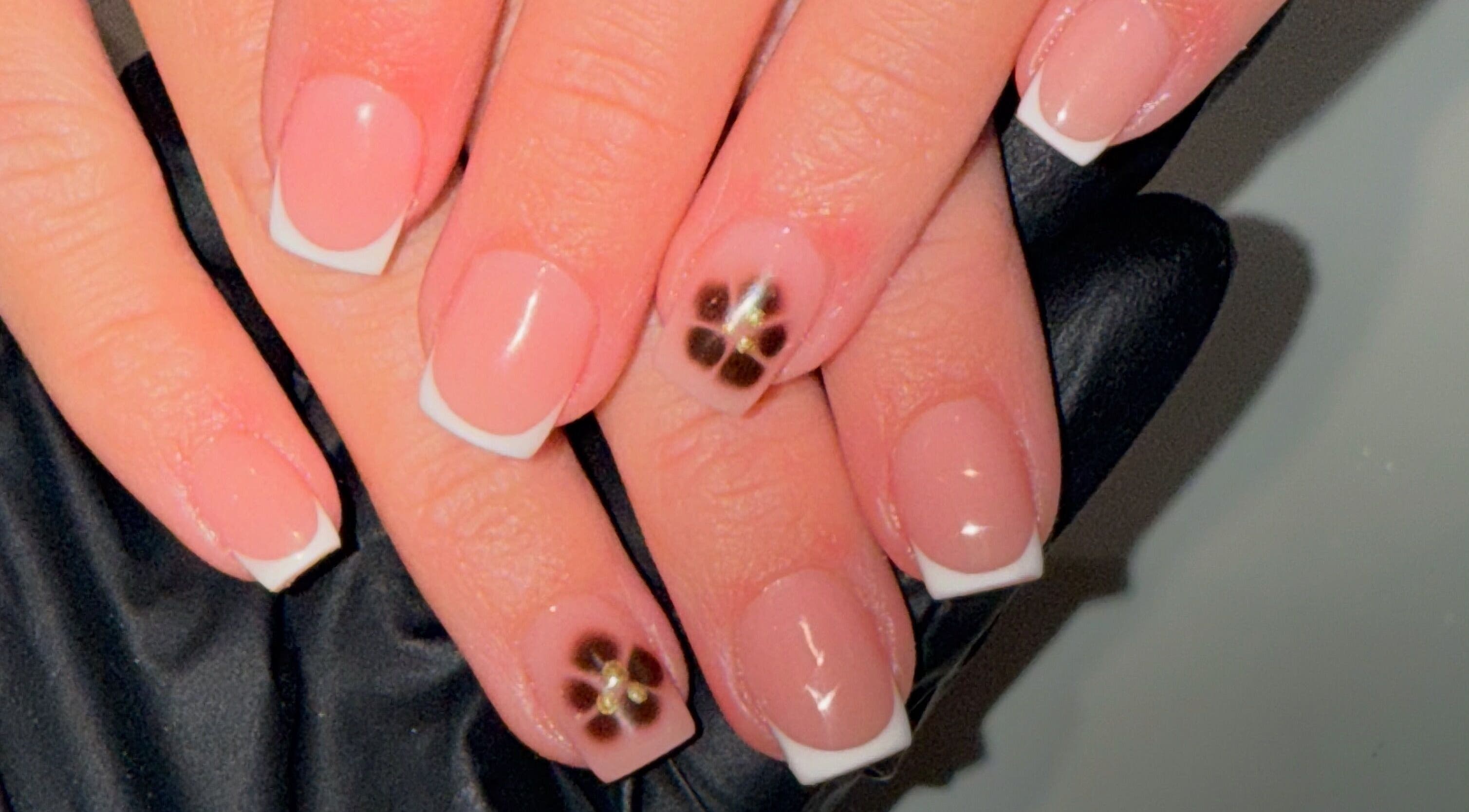 Elegant French manicure with floral accents at Lindsey Marriott Nails, Blackpool, England, GB.