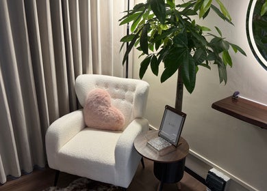 Comfortable corner at The Lash Crew, Marine Parade, SG with plush chair, heart pillow, and inviting decor.