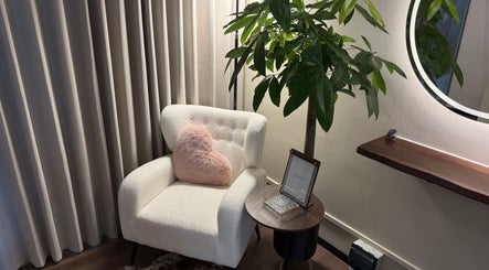Comfortable corner at The Lash Crew, Marine Parade, SG with plush chair, heart pillow, and inviting decor.