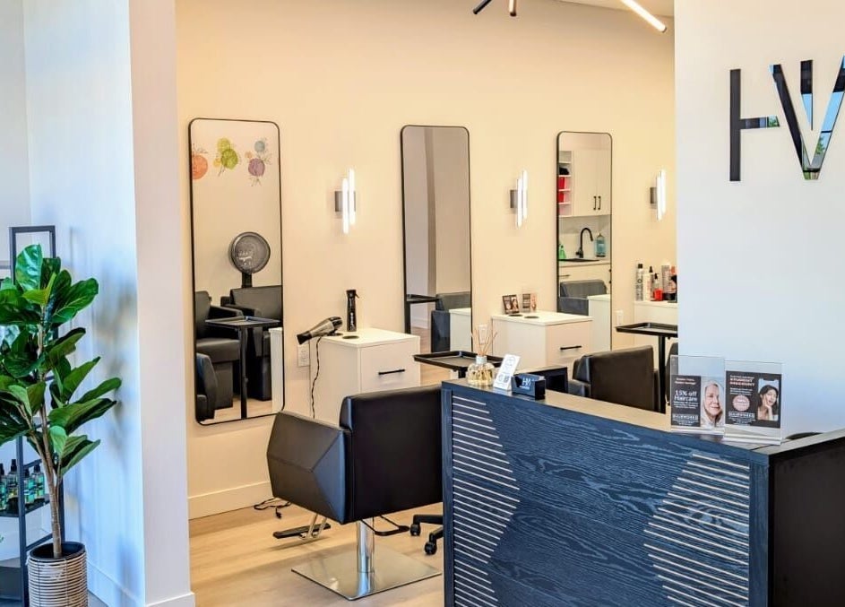 Modern interior of Hairworks Salon Windsor in Lasalle, Ontario, CA featuring stylish chairs and mirrors.