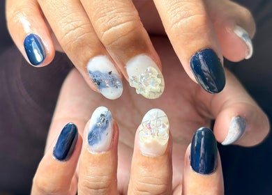 Desain kuku elegan di AgnesnazMakeup, Jawa Barat, dengan warna biru dan elemen artistik cemerlang.