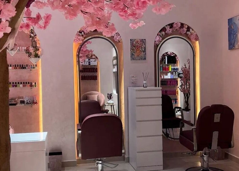 Elegant interior of High End Details Beauty Salon in Sharjah featuring cherry blossom decor and stylish mirrors.