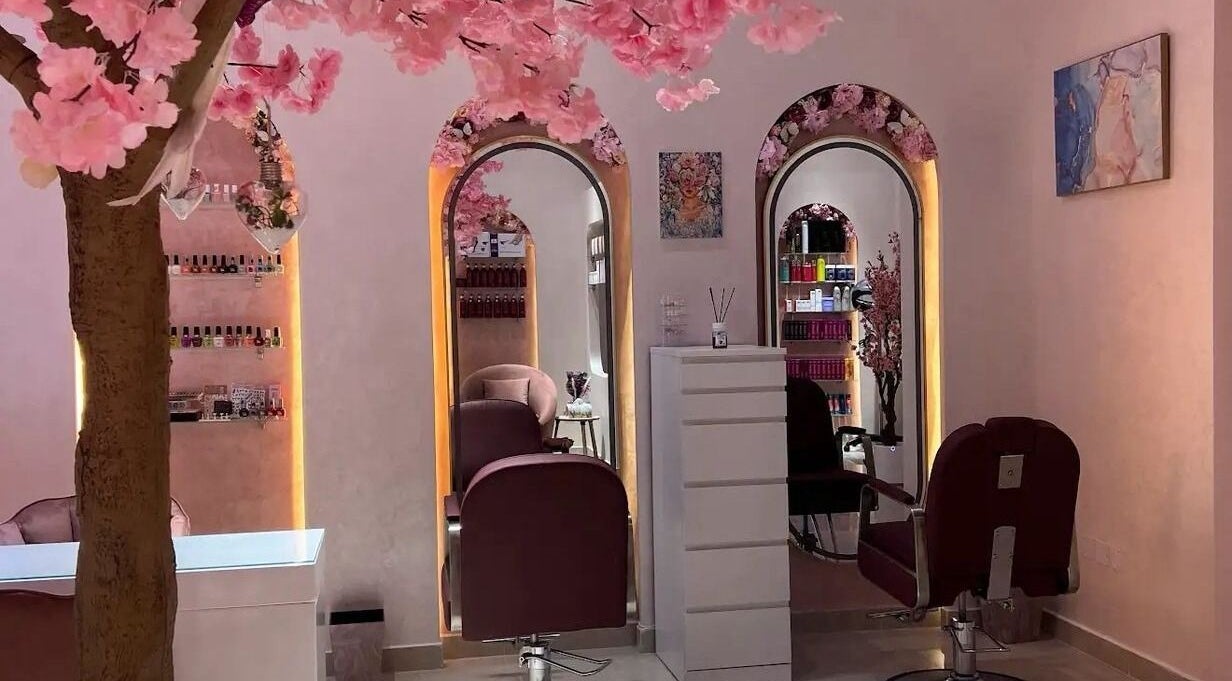 Elegant interior of High End Details Beauty Salon in Sharjah featuring cherry blossom decor and stylish mirrors.