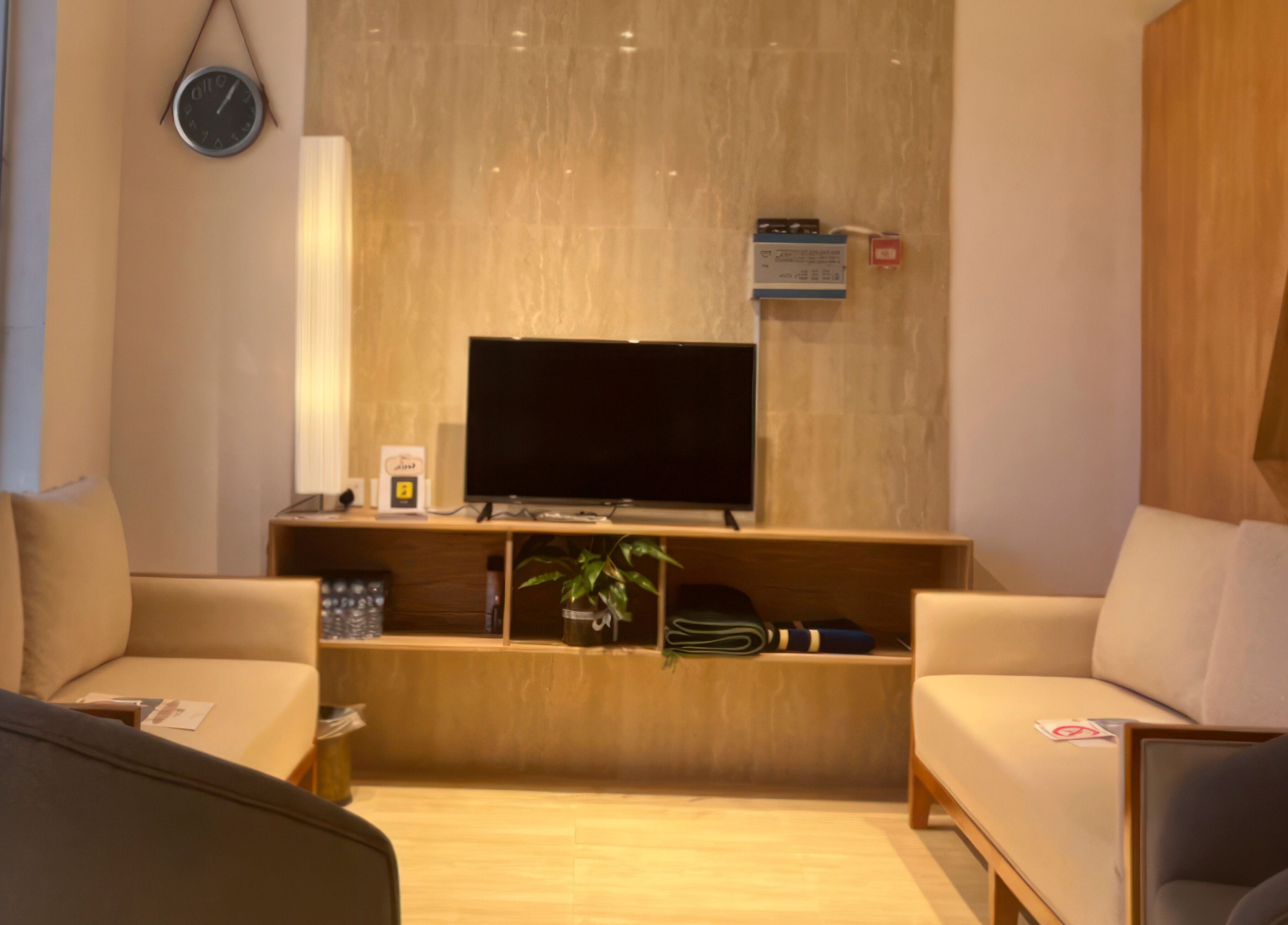 منطقة استقبال حديثة في 4D Barbershop بالرياض، الرياض، تعرض تلفاز وأرائك مريحة.