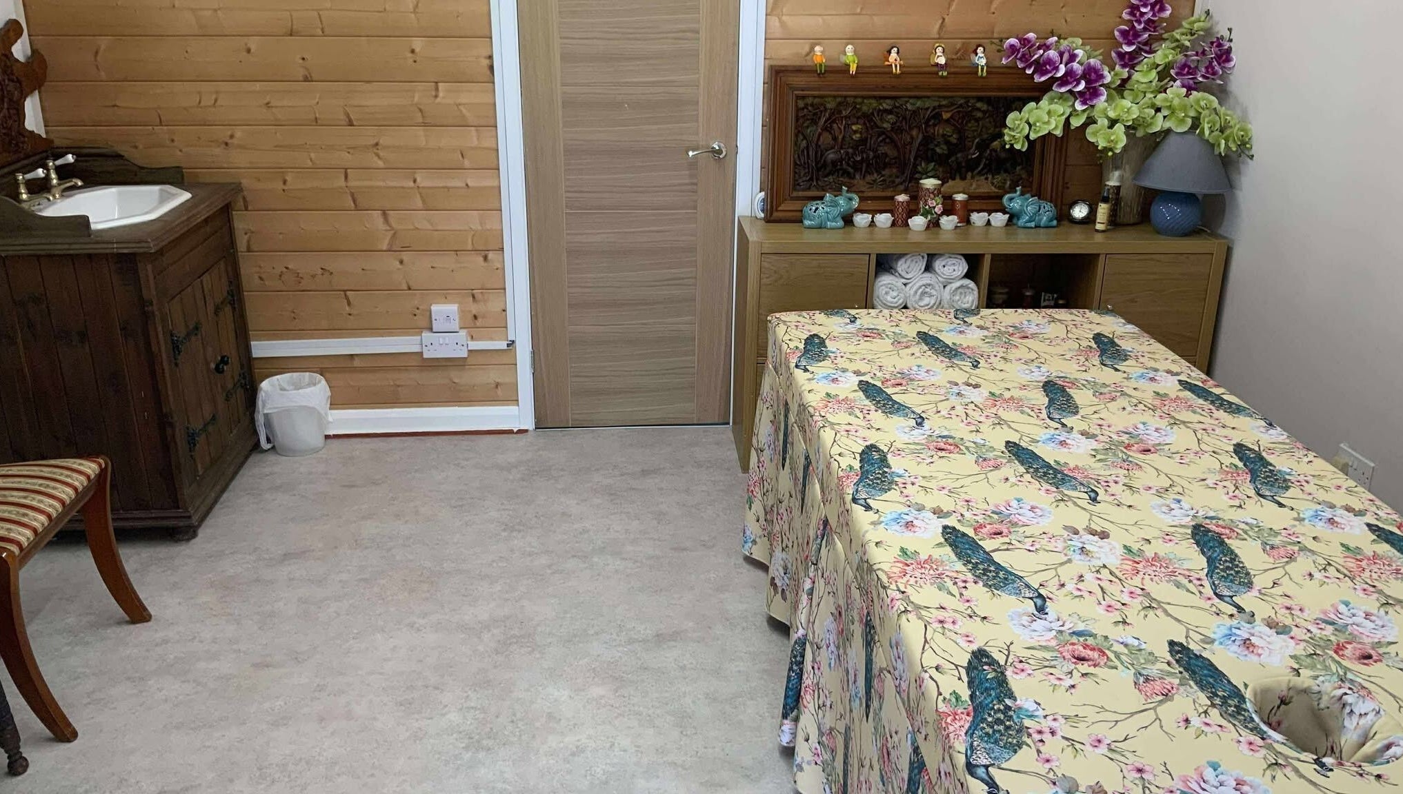 Cozy therapy room at Oak Barn Thai Massage in Lingfield, Newchapel, England, GB with floral decor and wooden accents.