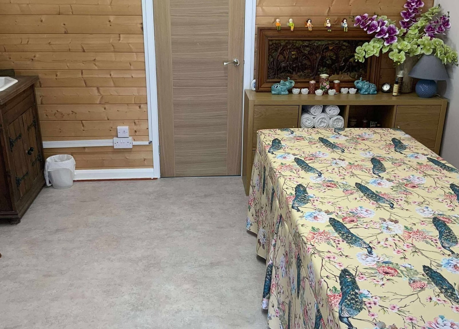 Cozy therapy room at Oak Barn Thai Massage in Lingfield, Newchapel, England, GB with floral decor and wooden accents.