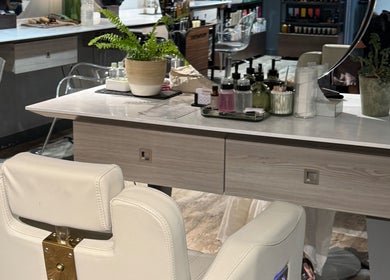 Elegant styling station at Gina Conway Beauty, London, England, GB. Features a plush chair and chic decor.