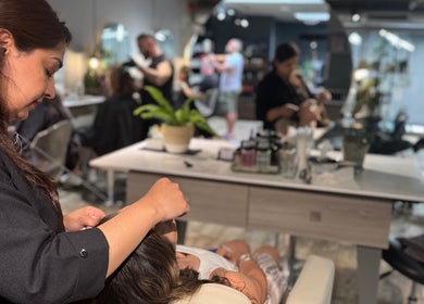 A stylist at Gina Conway Beauty in London, England, GB provides a relaxing salon service.