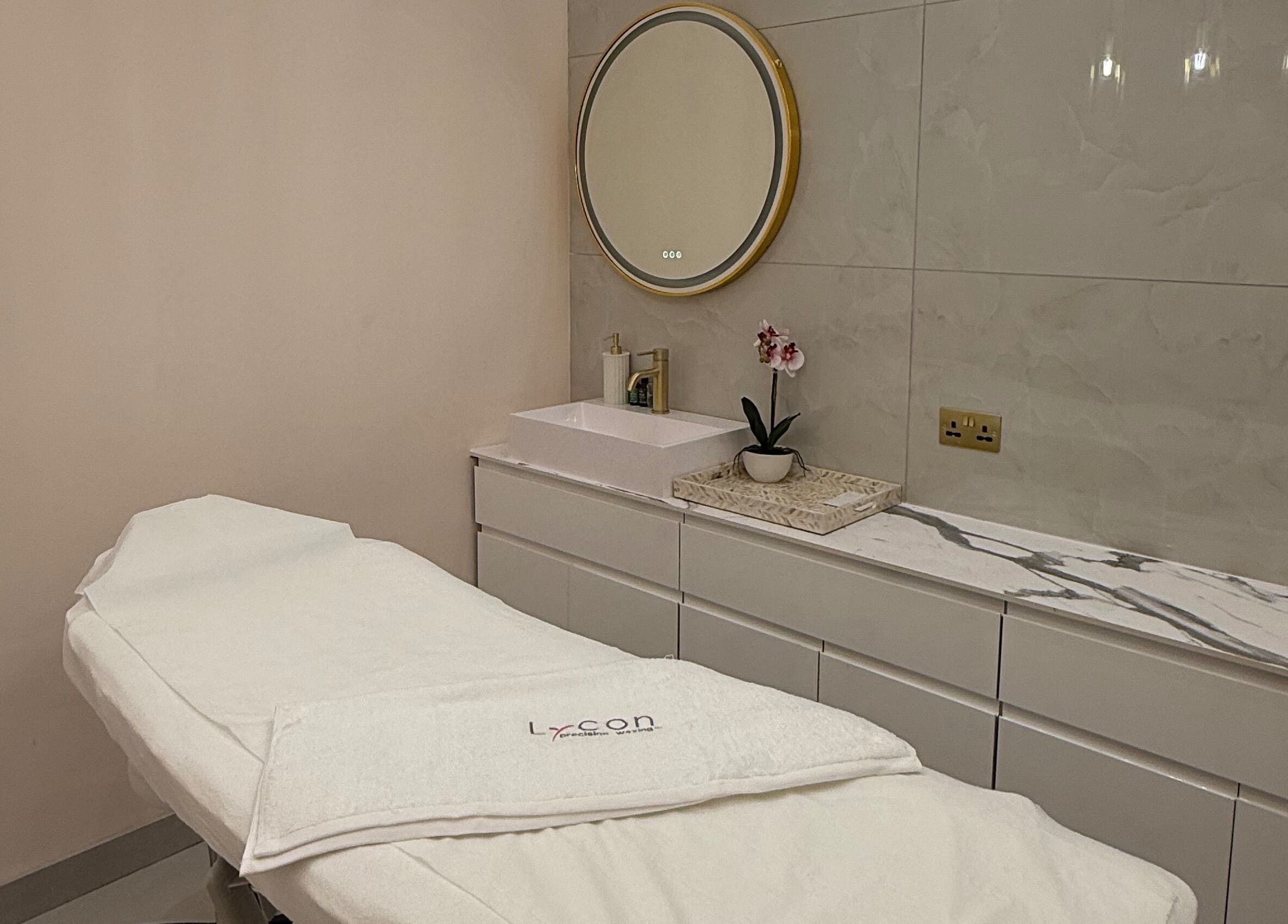 Elegant treatment room at 107 Putney high street SW15 1SS, London, England, GB, with a massage bed and vanity.