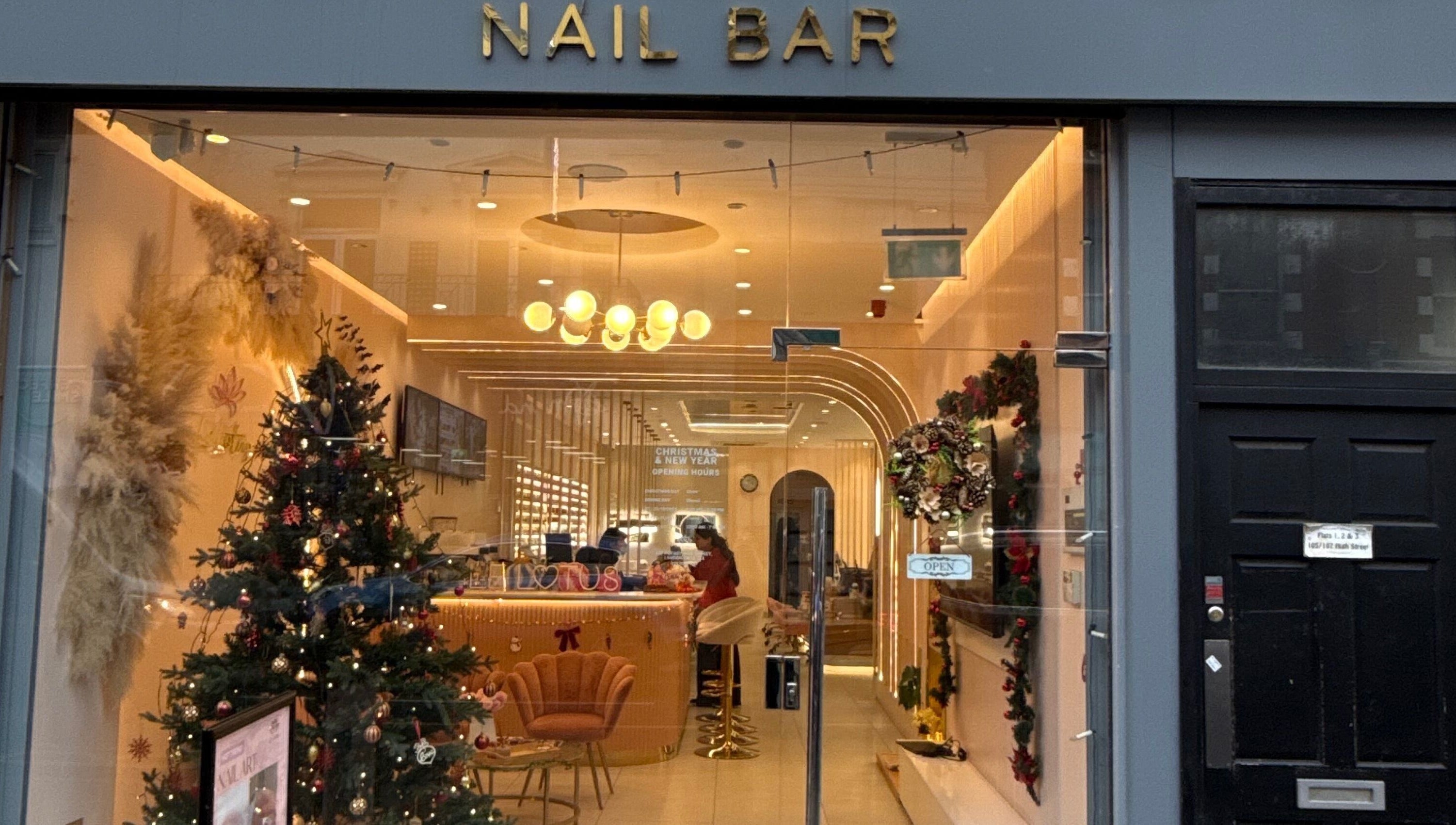 Festive Fab & Fancy nail bar warmly lit with festive decor in London, England, GB.