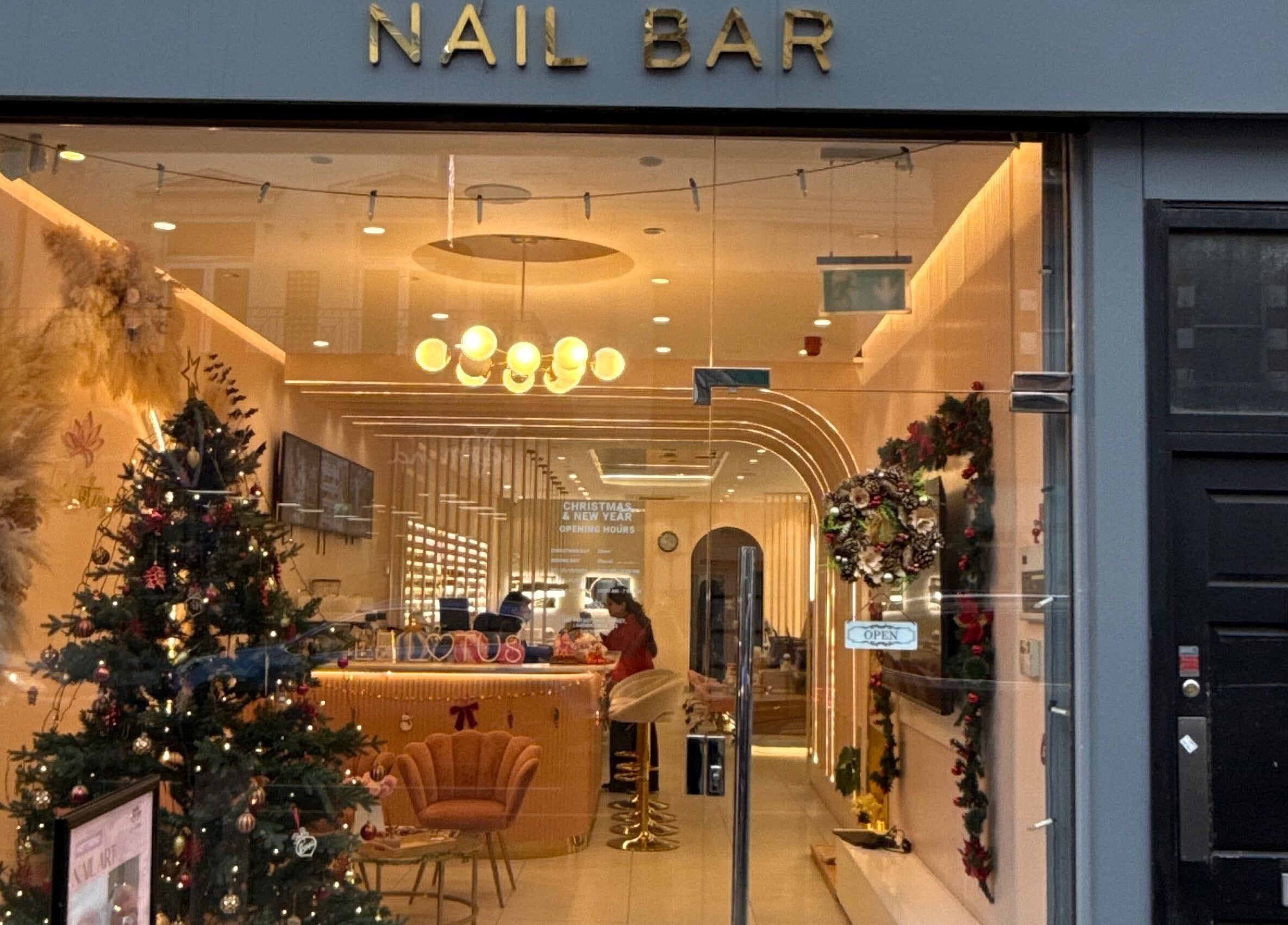 Festive Fab & Fancy nail bar warmly lit with festive decor in London, England, GB.
