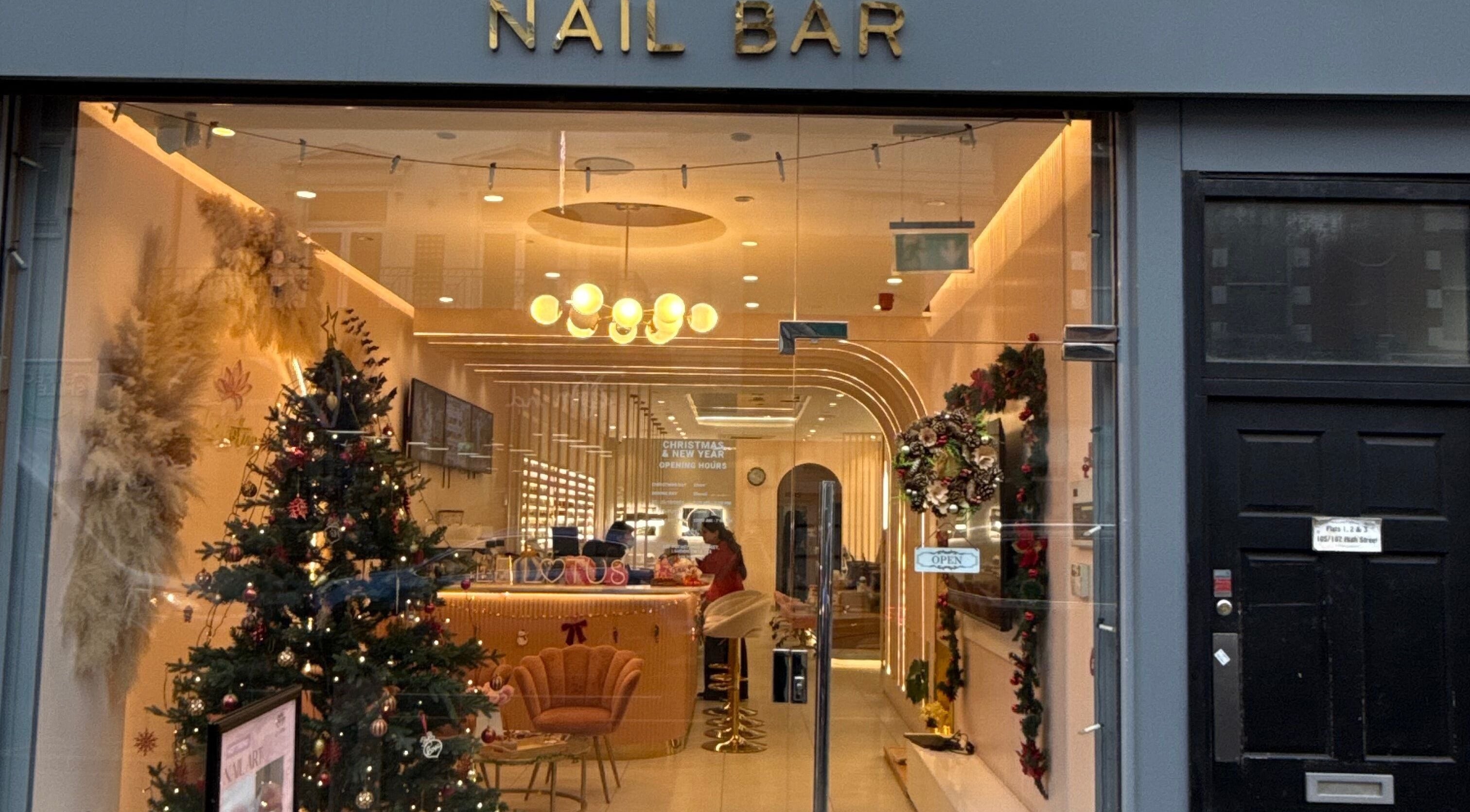 Festive Fab & Fancy nail bar warmly lit with festive decor in London, England, GB.