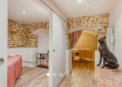 Salle de détente en pierre au Centre New Face, Paris, Île-de-France, FR, avec table de massage et statue élégante.