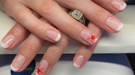 Beautiful French manicure with red bow design at Nu Nails And Beauty, Hemel Hempstead, England, GB.