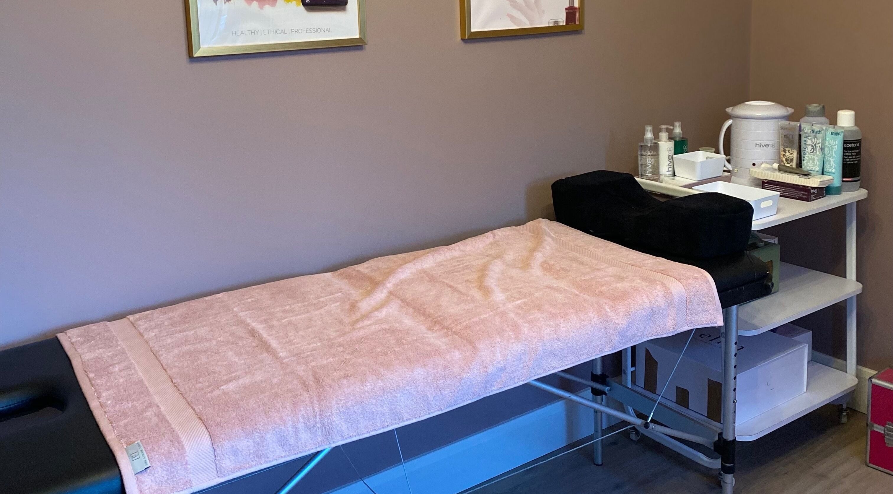 Relaxing treatment room at Nu Nails And Beauty, Hemel Hempstead, England, GB with a massage bed and spa essentials.