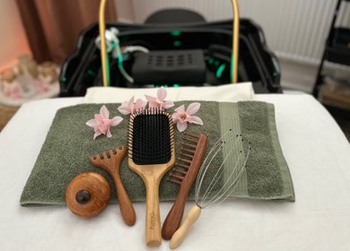 Orchideen und Massagegeräte im Head Spa Lounge - Grömitz, Schleswig-Holstein, DE, auf einem Handtuch.