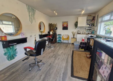 Elegant interior of Hairbyanna salon, Limerick, County Clare, IE showcasing styling stations and hair products.