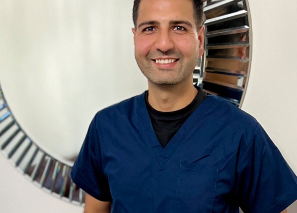 Friendly specialist at JAS Aesthetics, Coventry, England, GB, standing in front of a stylish mirror.