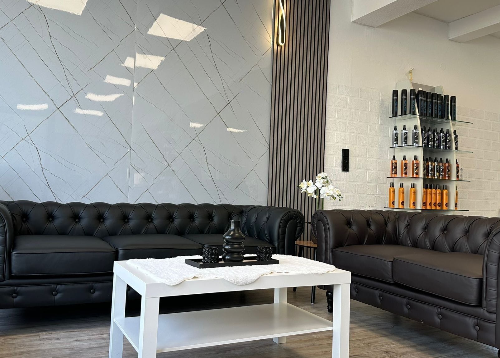 Elegante Wartebereich bei STYLEHAUS in Waldbreitbach, DE mit Ledersofas und moderner Dekoration.