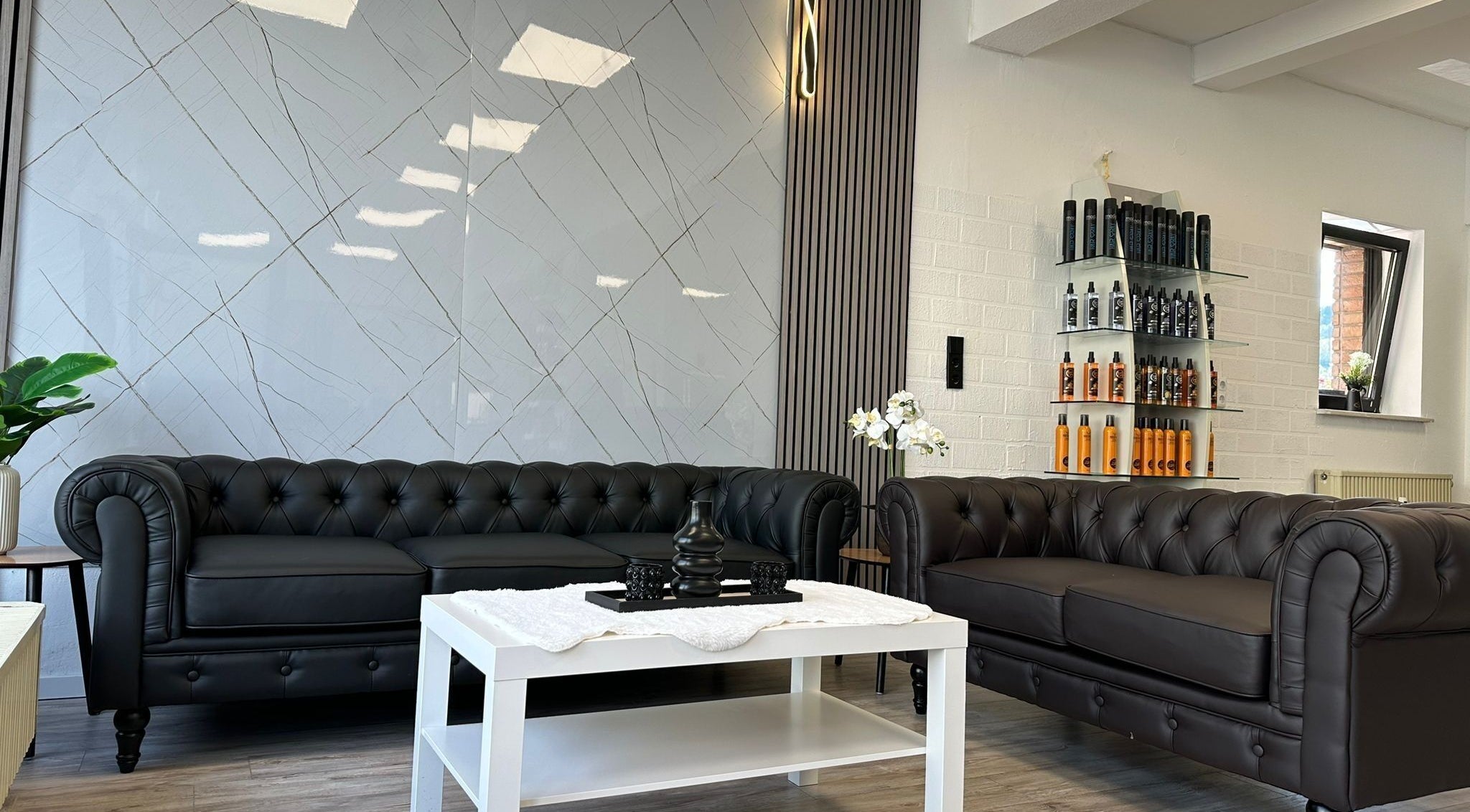 Elegante Wartebereich bei STYLEHAUS in Waldbreitbach, DE mit Ledersofas und moderner Dekoration.