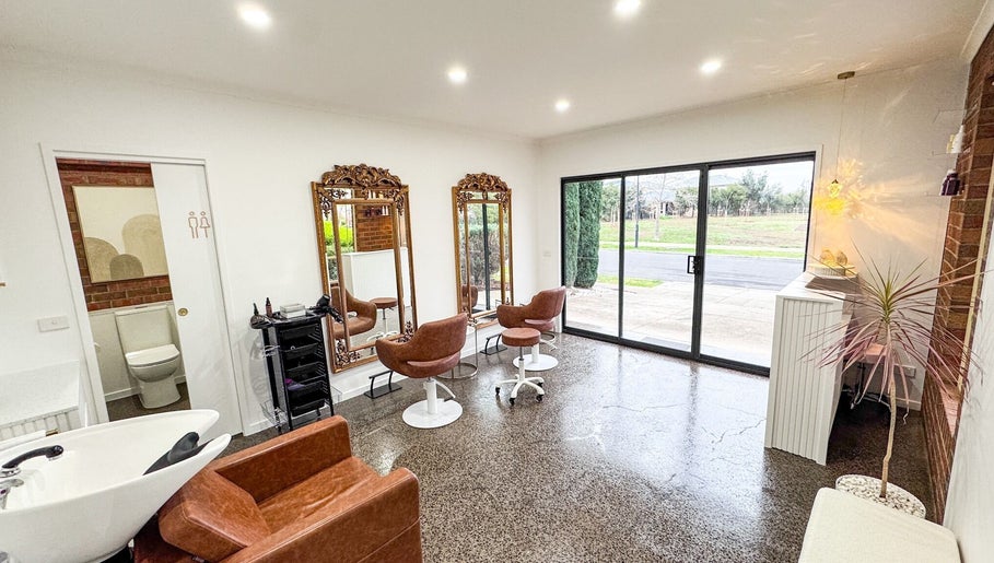 Chic interior of Renz Hair Studio in Melbourne, Victoria, AU with modern chairs, mirrors, and stylish decor.