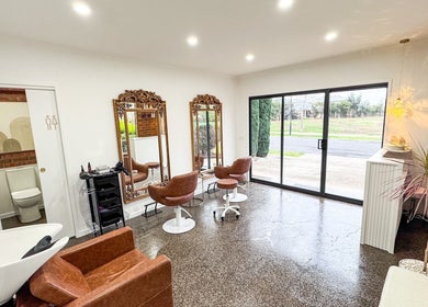 Chic interior of Renz Hair Studio in Melbourne, Victoria, AU with modern chairs, mirrors, and stylish decor.