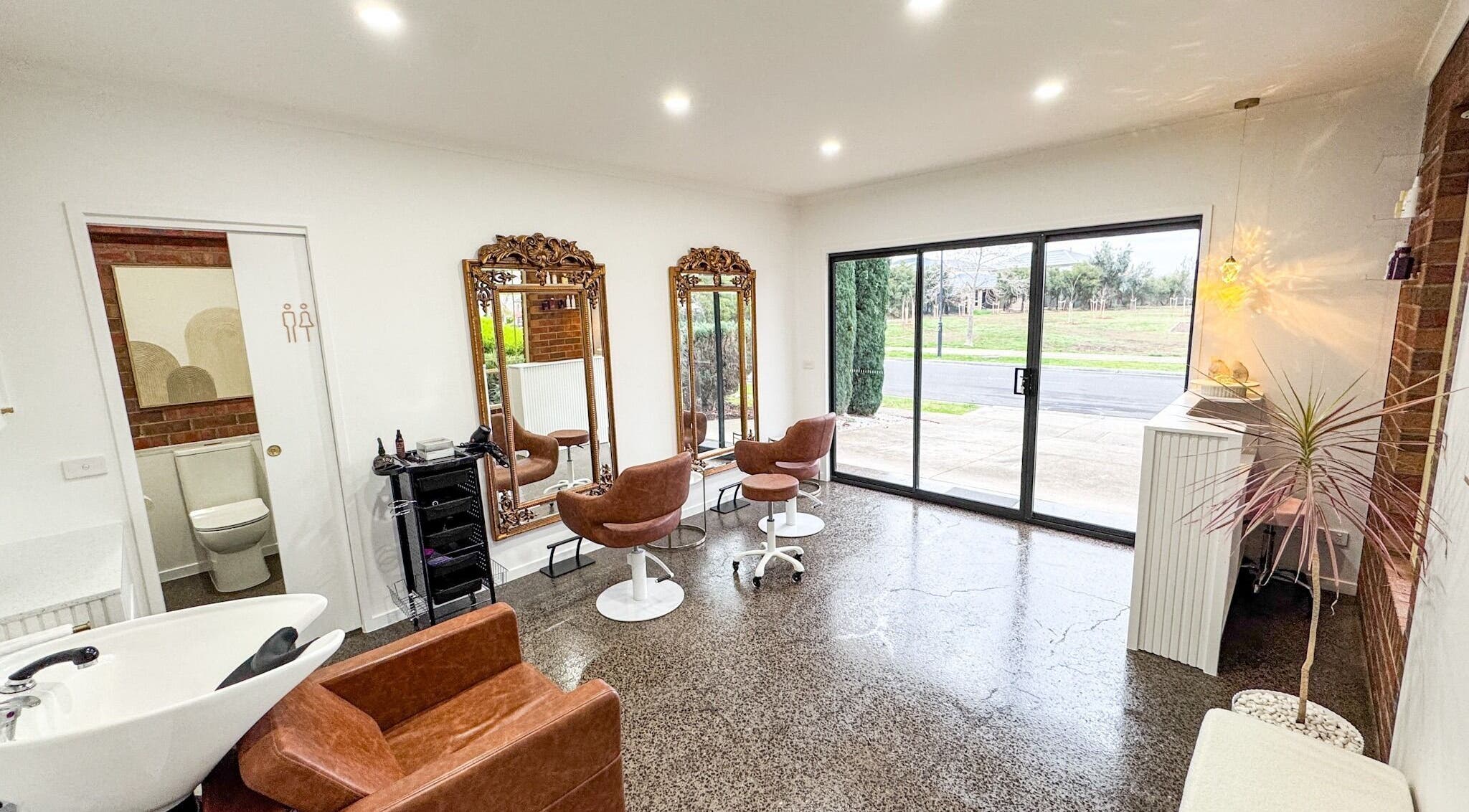 Chic interior of Renz Hair Studio in Melbourne, Victoria, AU with modern chairs, mirrors, and stylish decor.