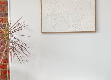 Stylish decor at Renz Hair Studio, Melbourne, Victoria, AU featuring textured white art and indoor plant.