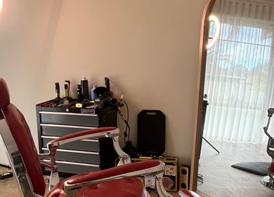 B The Barber in Perth, Western Australia, AU features a classic red barber chair and styling tools.