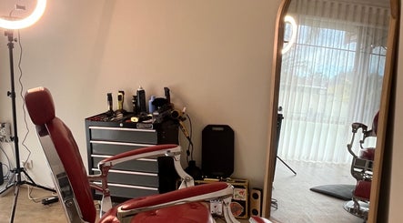 B The Barber in Perth, Western Australia, AU features a classic red barber chair and styling tools.