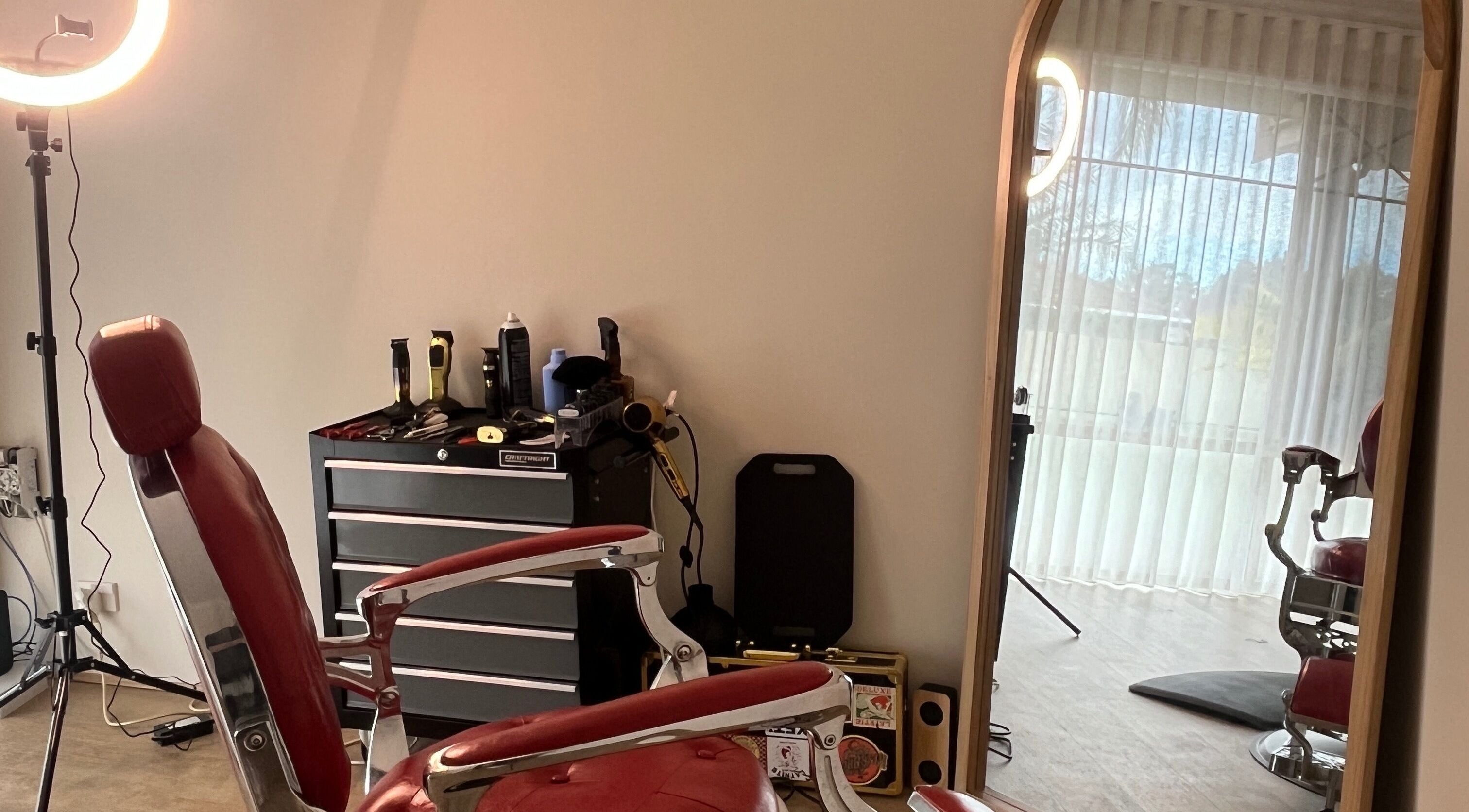 B The Barber in Perth, Western Australia, AU features a classic red barber chair and styling tools.