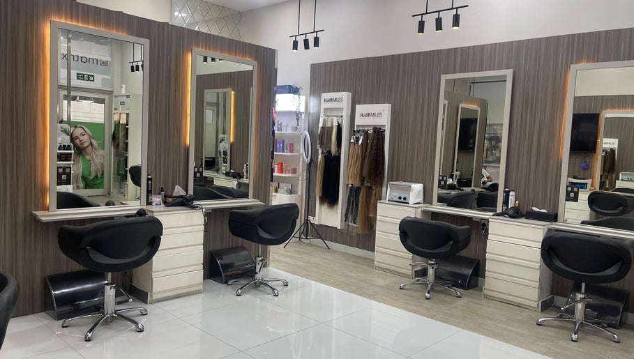 Modern salon interior at Dreams Salon, Dubai, AE, featuring stylish chairs and large mirrors.