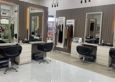 Modern styling stations at Dreams Salon, Dubai, AE, featuring sleek mirrors and luxurious chairs.