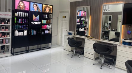 Modern salon interior at Dreams Salon, Dubai, AE with product displays and sleek styling stations.