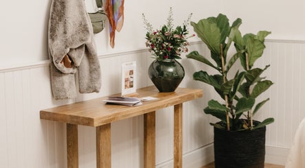 Cozy entrance at Pascale Dermal Aesthetics, Stellenbosch, featuring elegant decor and a lush plant.