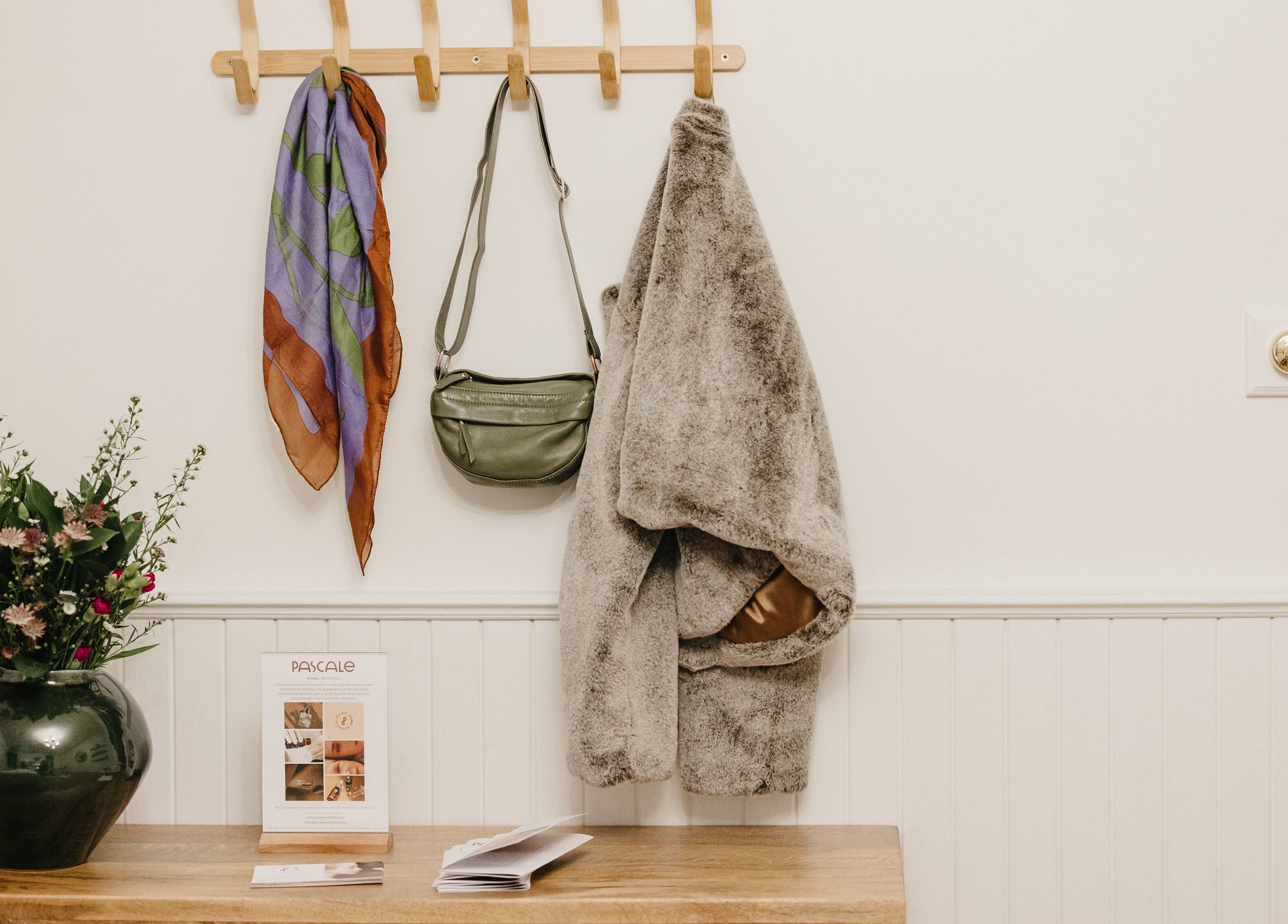 Inviting entryway with coat, bag, and vase at Pascale Dermal Aesthetics, Stellenbosch, Western Cape, ZA.