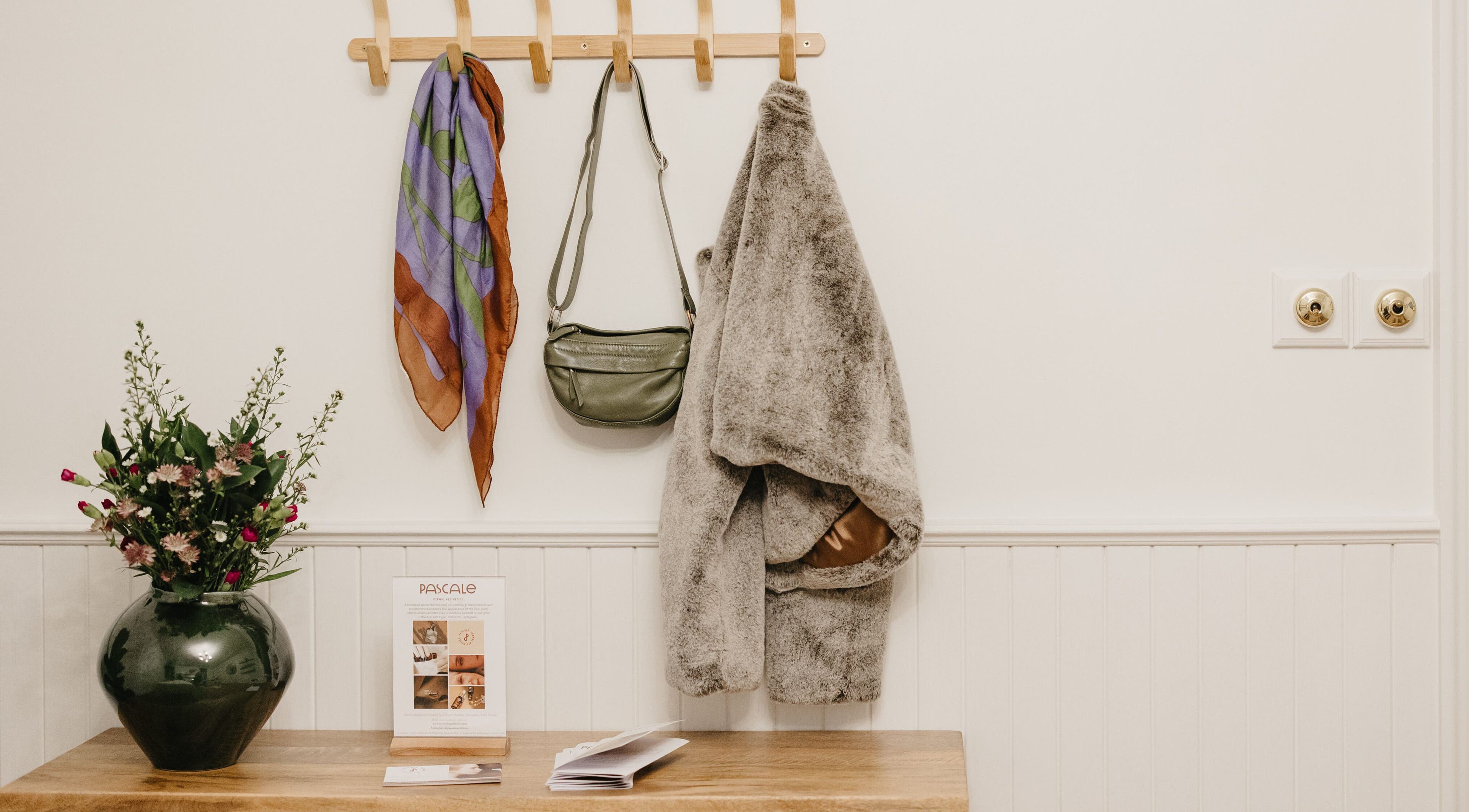 Inviting entryway with coat, bag, and vase at Pascale Dermal Aesthetics, Stellenbosch, Western Cape, ZA.