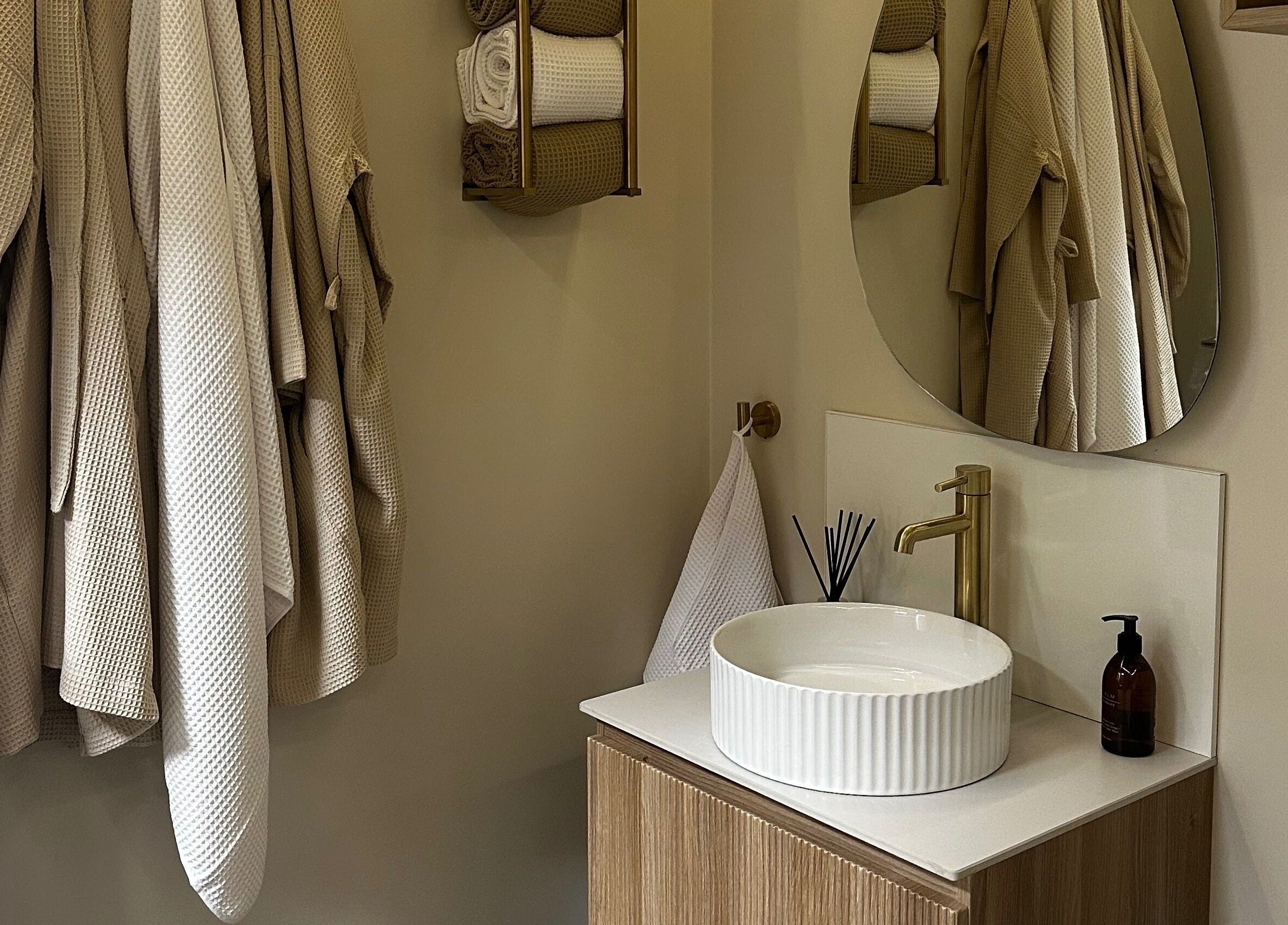 Luxurious bathroom at Rituals Holistic Massage, Cardiff, Wales, GB, featuring robes and a stylish vanity.